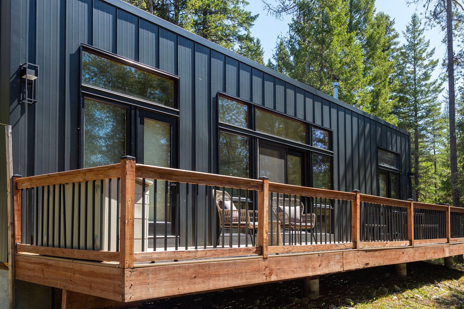 Modern cabin with a wraparound wood deck in the pines at North Star Ranch near Whitefish