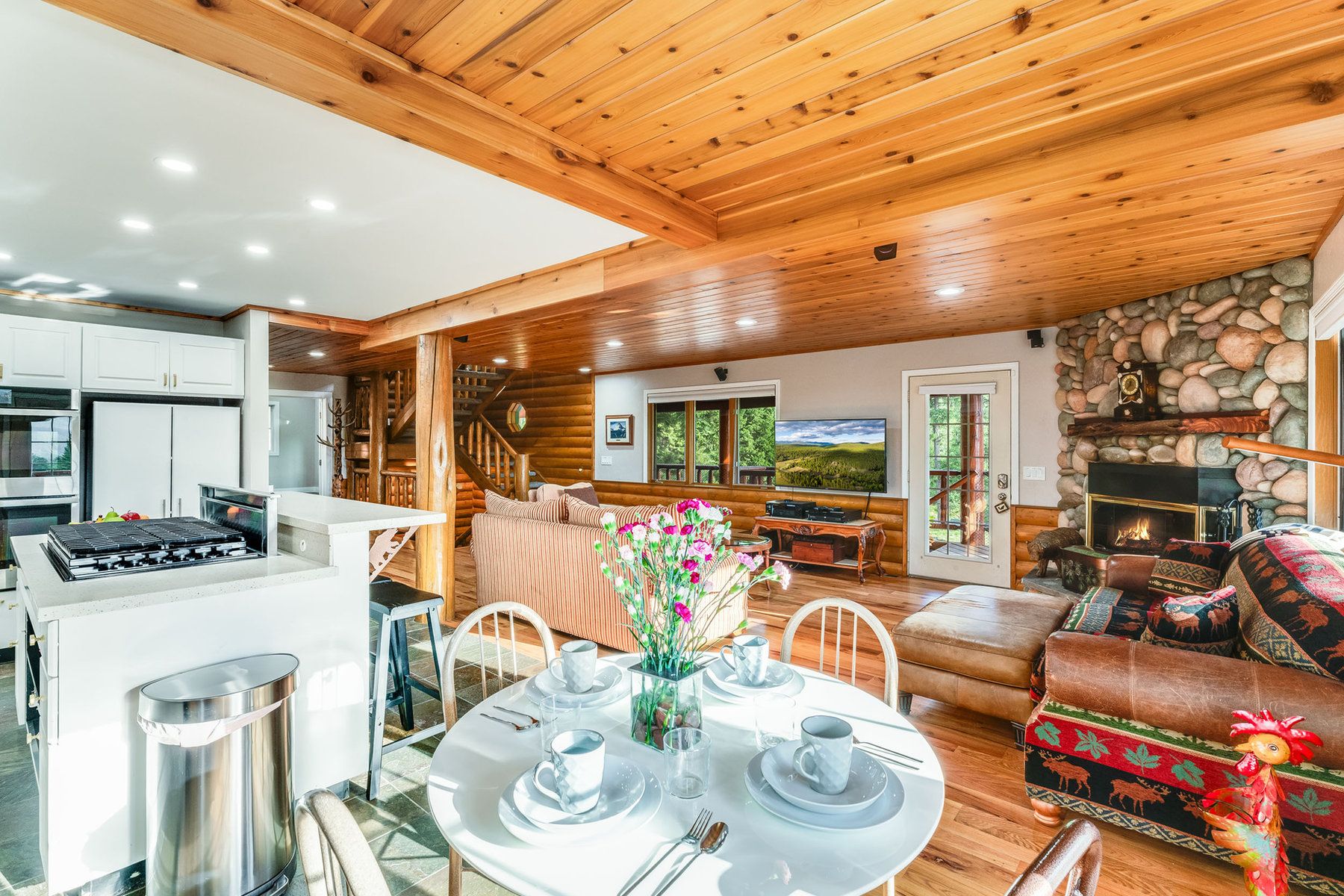 Chalet kitchen and dining table with a stone fireplace at North Star Ranch